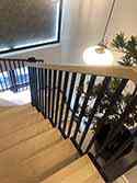 Zakřivené schodiště s ocelovou nosnou konstrukcí. Dřevěné schodišťové stupně.