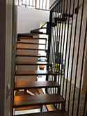 Zakřivené schodiště s ocelovou nosnou konstrukcí. Dřevěné schodišťové stupně.