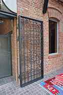 Ocelové dveře s práškovým lakovaným ocelovým rámem a výplní z ocelových tyčí.