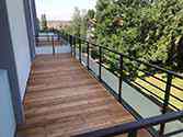 Balkony z ocelového profilu s dřevěnými deskami a zábradlí se skleněnou výplní
